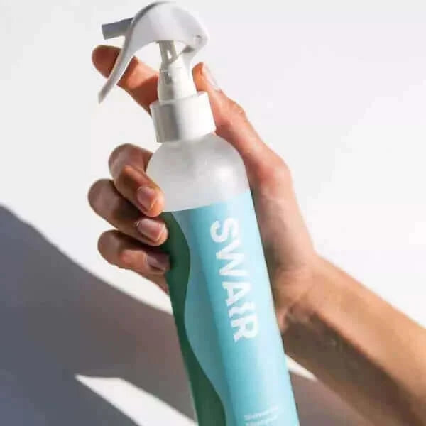 Woman holding  Showerless Shampoo 8 ounce bottle #size_8-oz